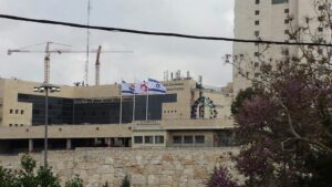 sop resize תרני אלומיניום קוני בגובה מטר התקנה באמצעות חבקים לקיר חיצוני מוגבה במדא מרחב ירושלים עם דגלי לאום ולוגו בגודל על מטר